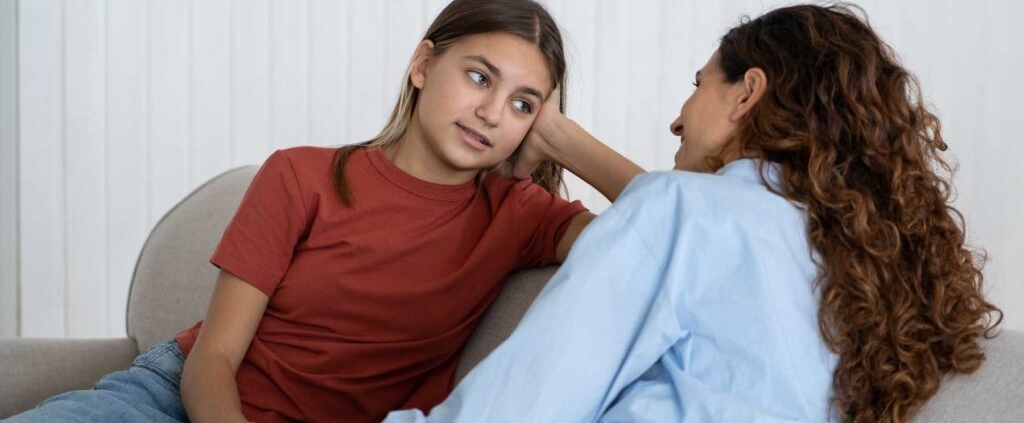 teen and mom sitting on couch looking at each other