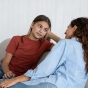 teen and mom sitting on couch looking at each other