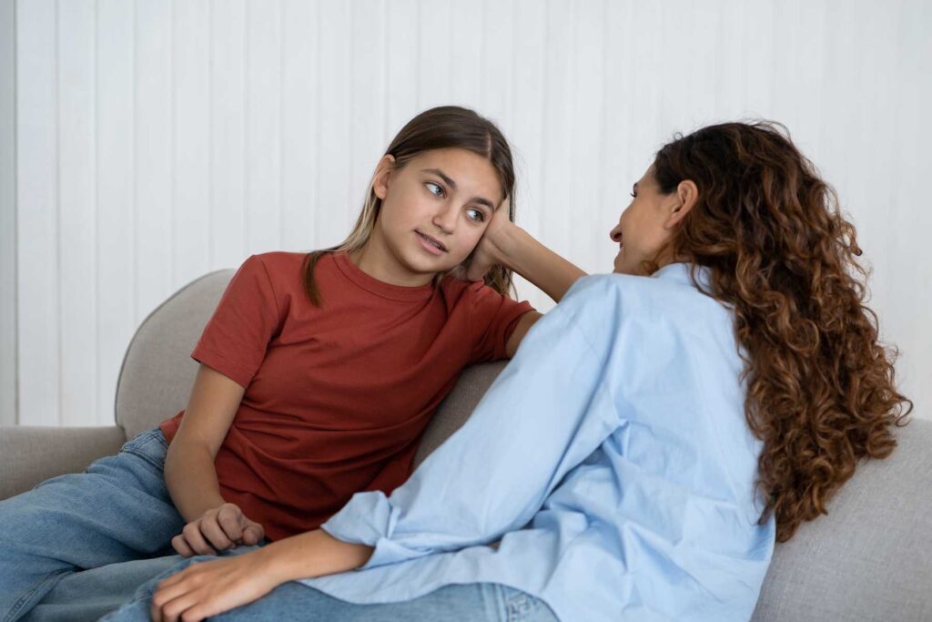 teen and mom sitting on couch looking at each other