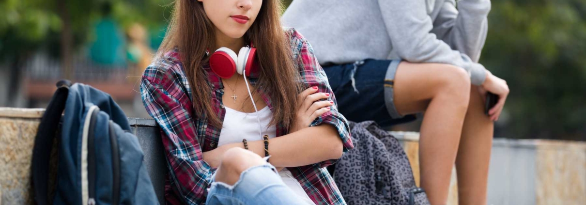 teen sitting with arms crossed and skateboard