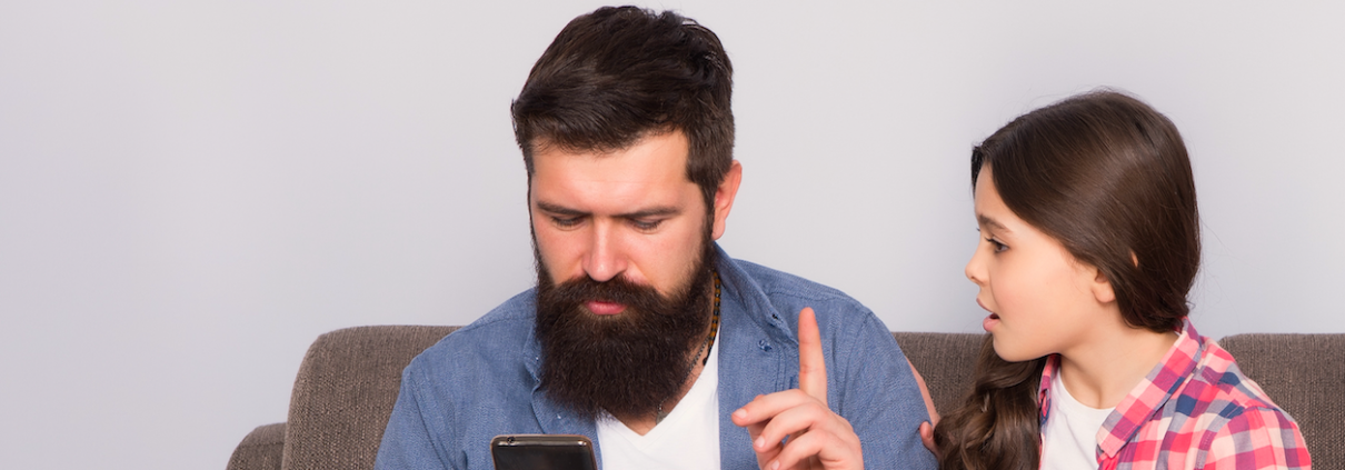 Dad holds up finger to teen as he looks at phone